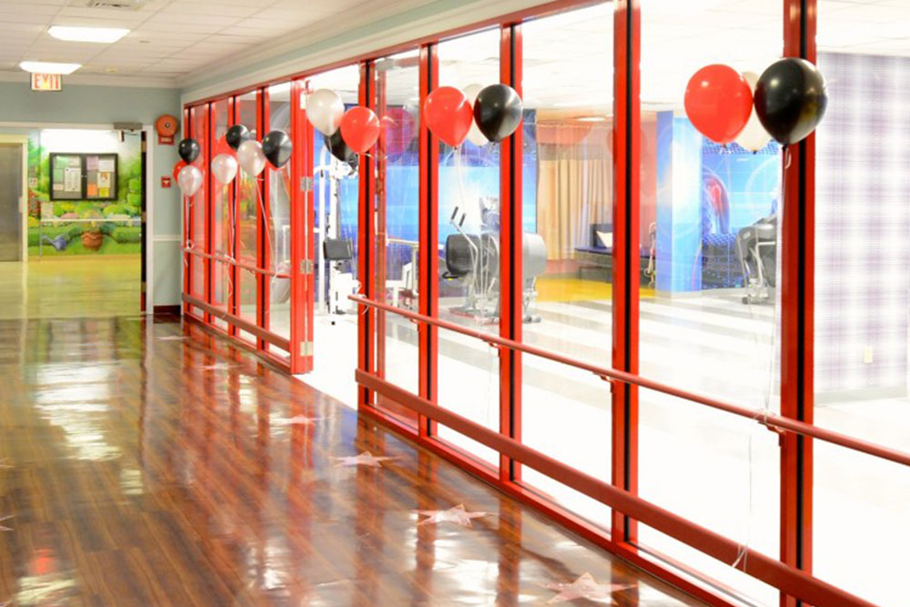 Hallway of East Neck Nursing Center filled with red, black, and white balloons.