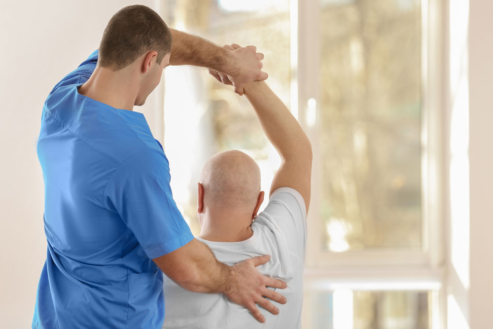 Physiotherapist working with elderly patient in clinic.